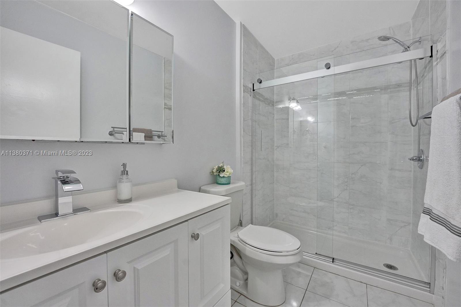 23360 Southwest 53rd Avenue, Unit E Boca Raton, FL 33433 - Photo 19 of 37 a bathroom with a sink a toilet and shower