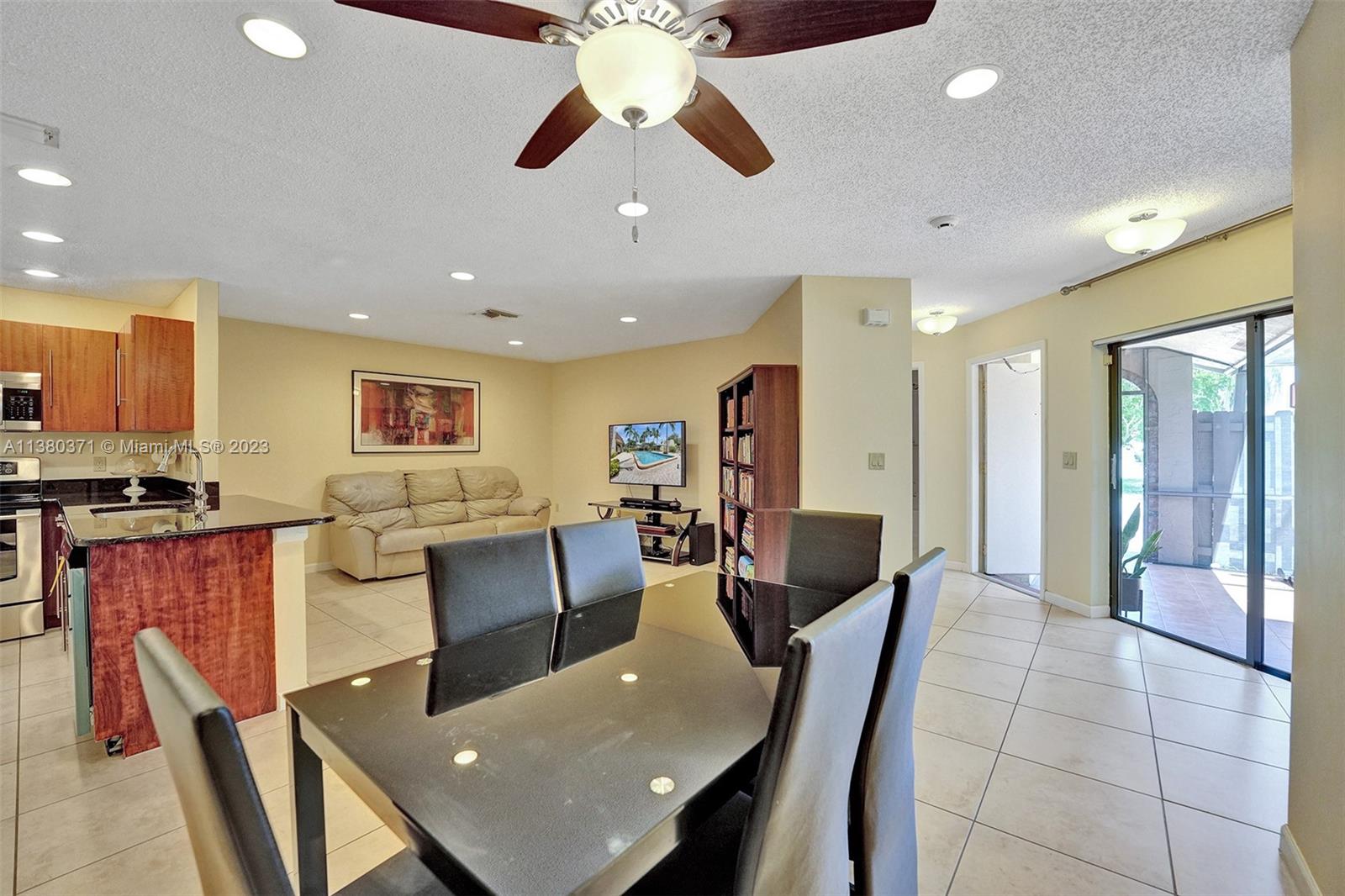 23360 Southwest 53rd Avenue, Unit E Boca Raton, FL 33433 - Photo 7 of 37 a living room with stainless steel appliances furniture a dining table and kitchen view