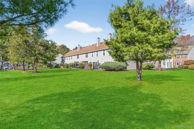 a view of a house with a big yard and large trees