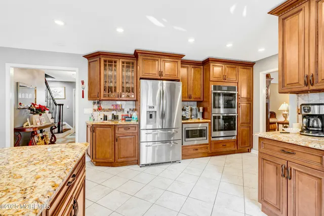 a kitchen with stainless steel appliances granite countertop a refrigerator and a stove top oven