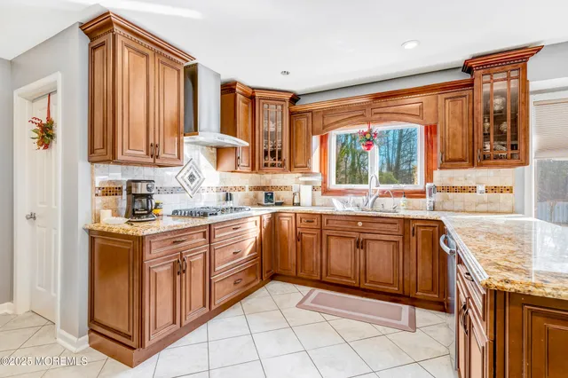 a kitchen with stainless steel appliances granite countertop a stove a sink and a microwave