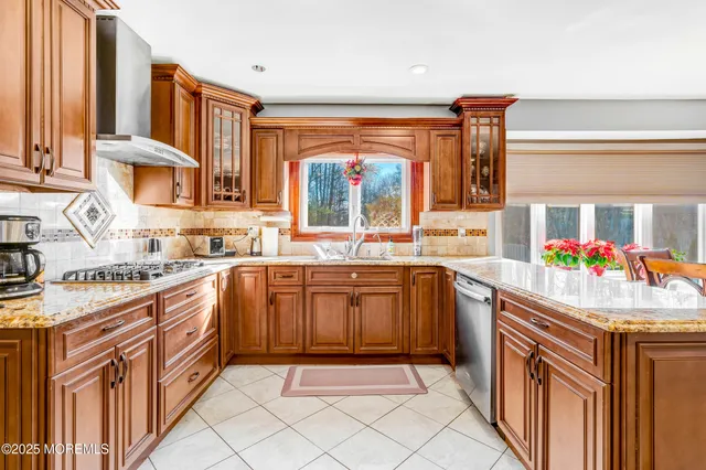 a kitchen with stainless steel appliances granite countertop a sink and a stove