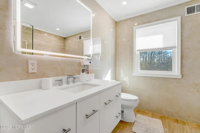 a bathroom with a sink a toilet and a mirror