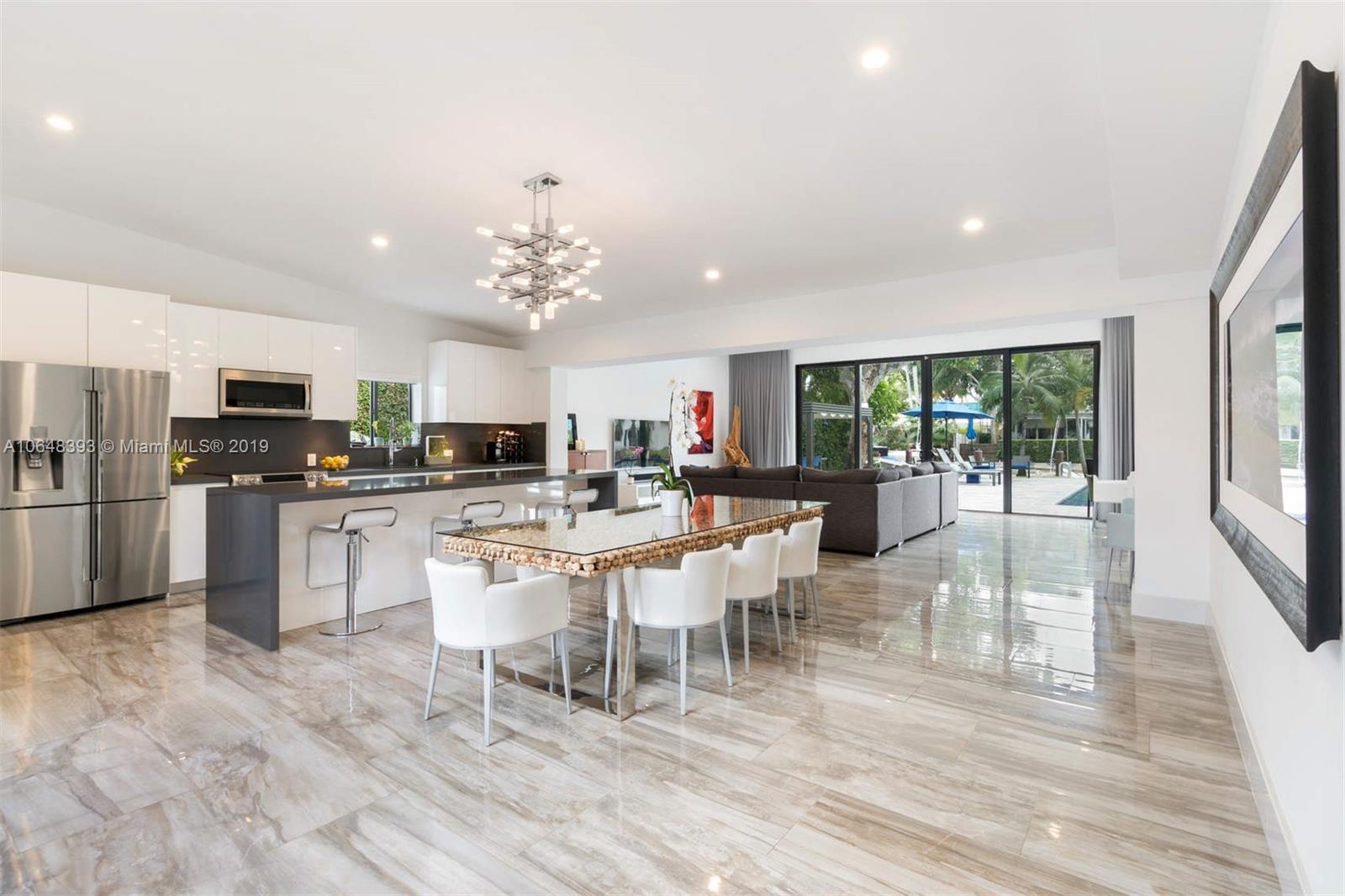 1880 Cleveland Road Miami Beach, FL 33141 - Photo 3 of 26 a kitchen with stainless steel appliances granite countertop a stove top oven a sink dishwasher a dining table and chairs with wooden floor