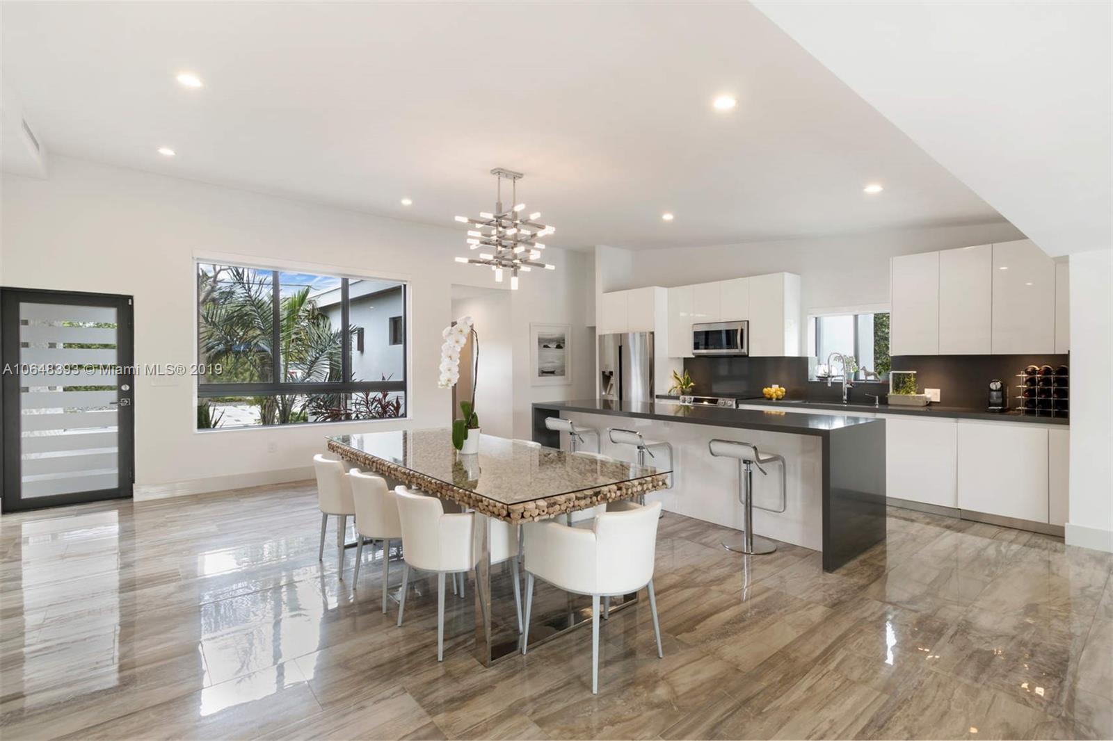1880 Cleveland Road Miami Beach, FL 33141 - Photo 6 of 26 a kitchen with stainless steel appliances kitchen island granite countertop a dining table chairs and view living room