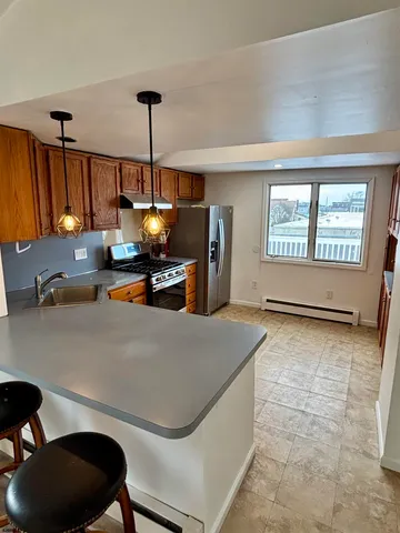 a kitchen with stainless steel appliances granite countertop a sink a stove and a refrigerator