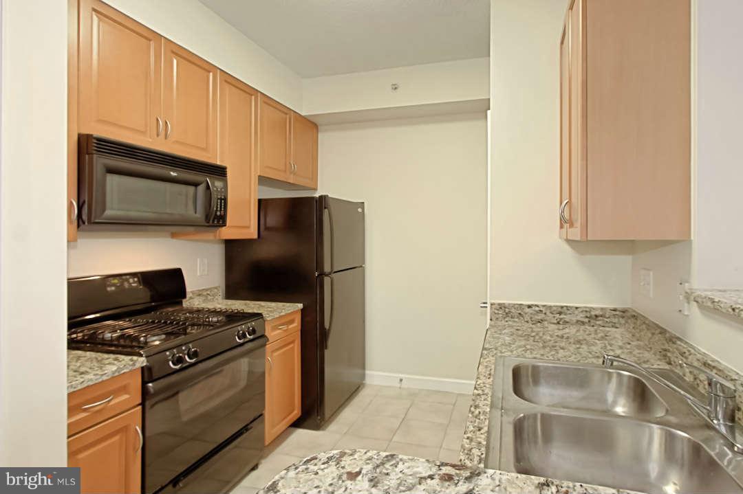 1111 25th Street Northwest, Unit 714 Washington, DC 20037 - Photo 16 of 28 a kitchen with stainless steel appliances granite countertop a stove a refrigerator and a microwave