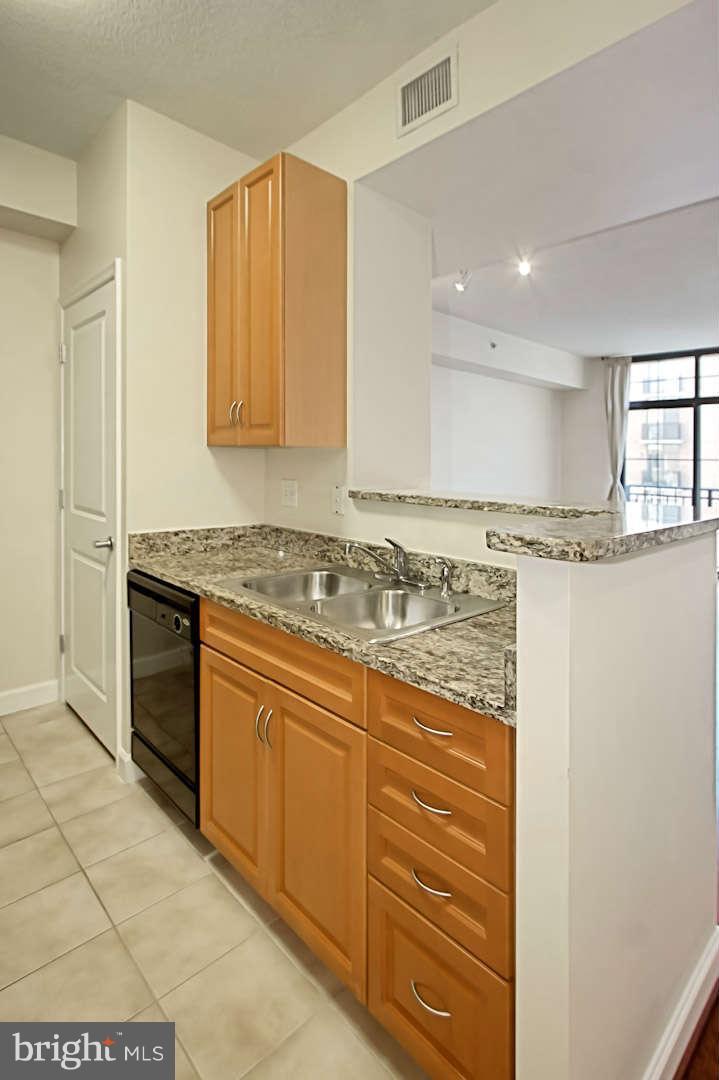 1111 25th Street Northwest, Unit 714 Washington, DC 20037 - Photo 18 of 28 a kitchen with granite countertop cabinets stainless steel appliances and a counter space