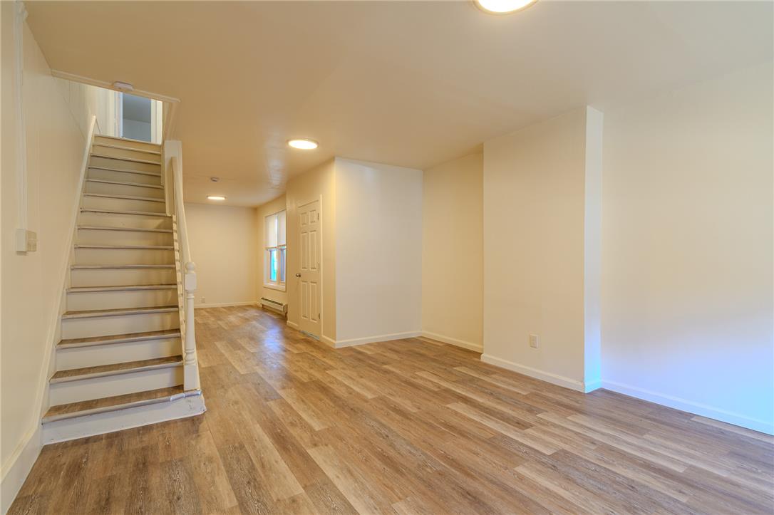 820 North 5th Street Allentown, PA 18102 - Photo 13 of 39 A spacious, naturally illuminated area featuring durable wood flooring, leading to a traditional staircase.