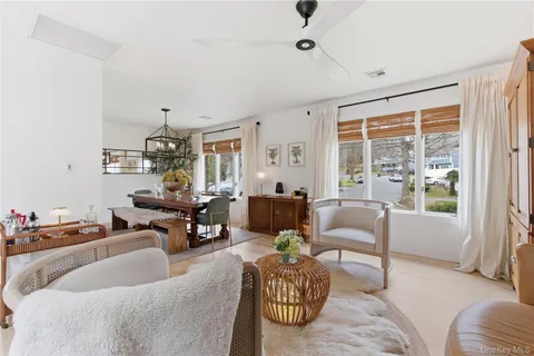 a living room with furniture a chandelier and a window