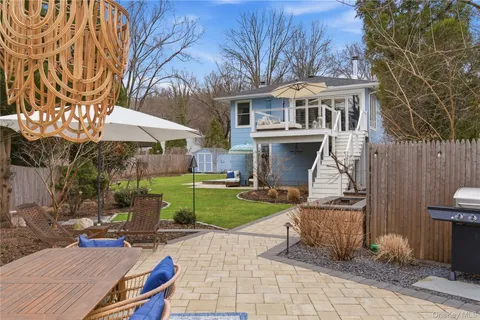 a view of a house with a yard potted plants and a table
