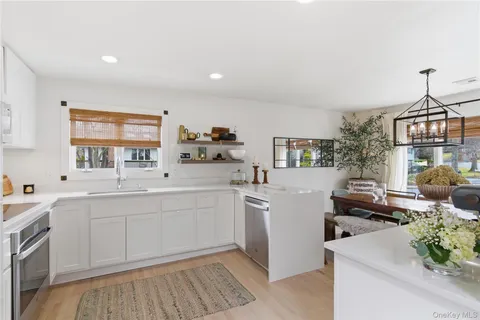 a kitchen with kitchen island white cabinets and white appliances