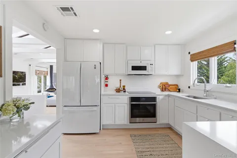 a kitchen with stainless steel appliances a stove a sink a refrigerator a center island and cabinets