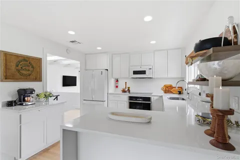 a kitchen with white cabinets and appliances