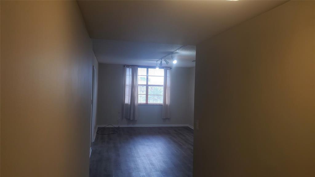 3910 Crystal Lake Drive, Unit 403 Deerfield Beach, FL 33064 - Photo 14 of 27 an empty room with wooden floor and windows