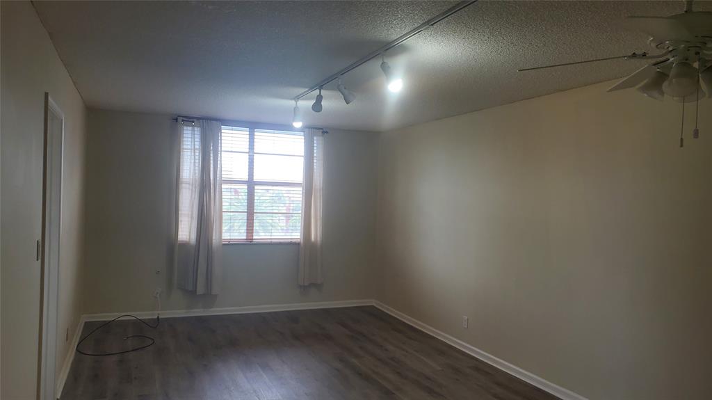 3910 Crystal Lake Drive, Unit 403 Deerfield Beach, FL 33064 - Photo 15 of 27 an empty room with wooden floor and windows