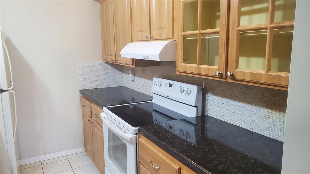 3910 Crystal Lake Drive, Unit 403 Deerfield Beach, FL 33064 - Photo 17 of 27 a kitchen with a sink and a stove top oven