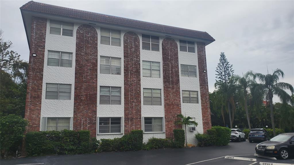 3910 Crystal Lake Drive, Unit 403 Deerfield Beach, FL 33064 - Photo 2 of 27 a front view of a building with a garden