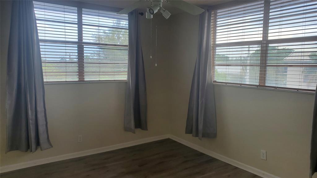 3910 Crystal Lake Drive, Unit 403 Deerfield Beach, FL 33064 - Photo 23 of 27 a view of an empty room with wooden floor and a window