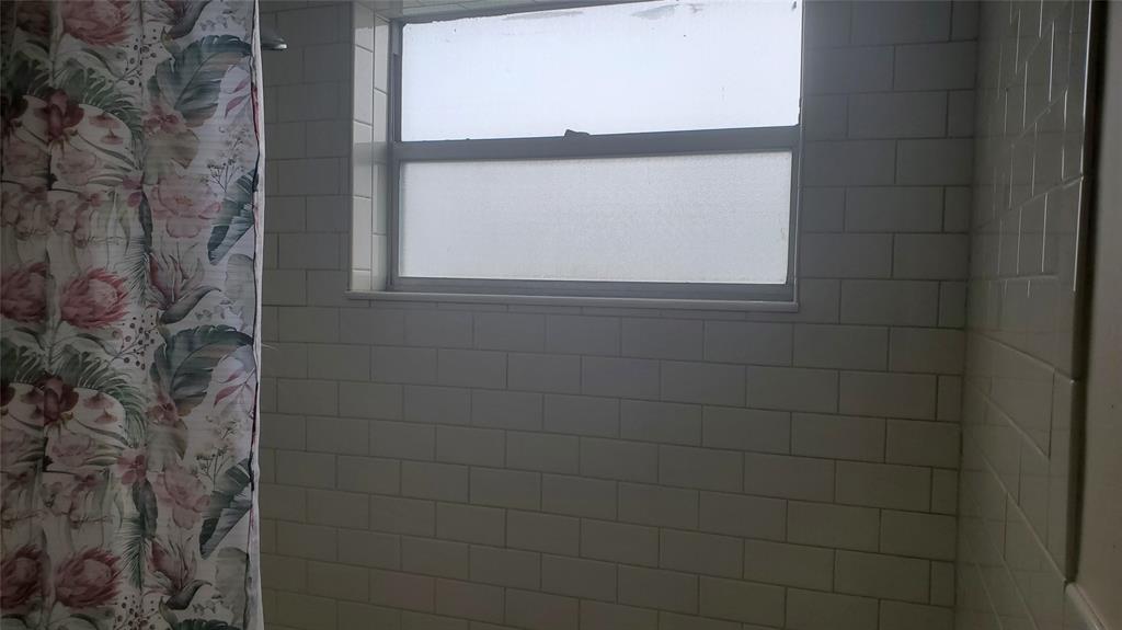 3910 Crystal Lake Drive, Unit 403 Deerfield Beach, FL 33064 - Photo 26 of 27 a bathroom with a window that has a shower curtain