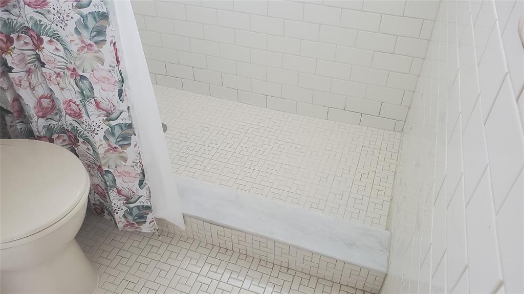 3910 Crystal Lake Drive, Unit 403 Deerfield Beach, FL 33064 - Photo 27 of 27 a bathroom with a toilet and a shower curtain