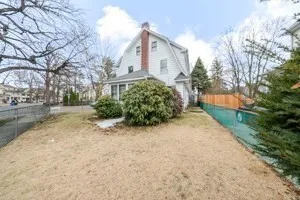 a front view of a house with a yard and trees