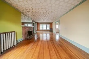 a view of empty room with wooden floor and fireplace