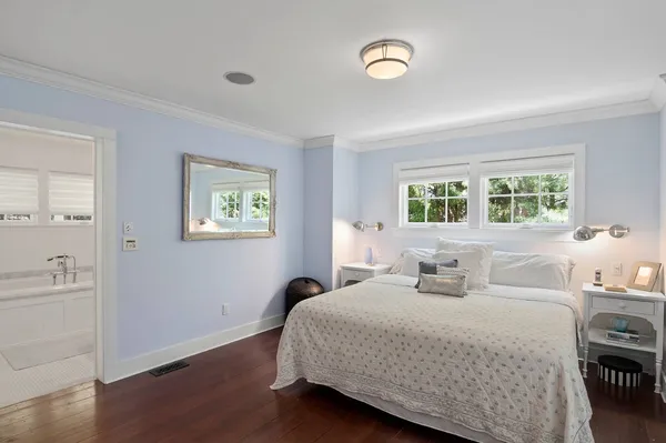 a bedroom with a large bed and a chandelier