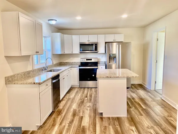 a kitchen with a stove a sink and a refrigerator