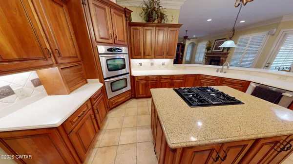 a kitchen with stainless steel appliances granite countertop a refrigerator and a stove top oven
