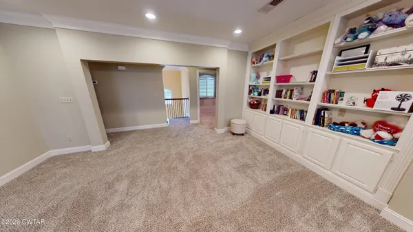 an empty room with a mirror and a ceiling fan