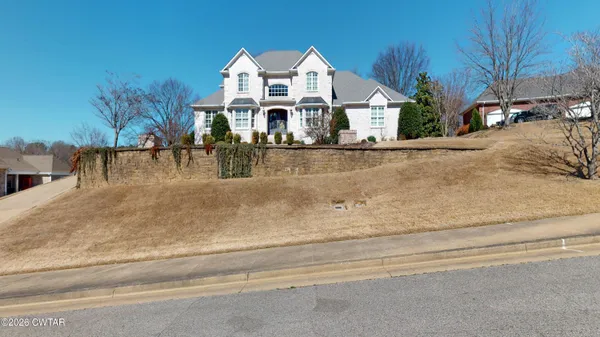 a view of a white house with a large road next to a road