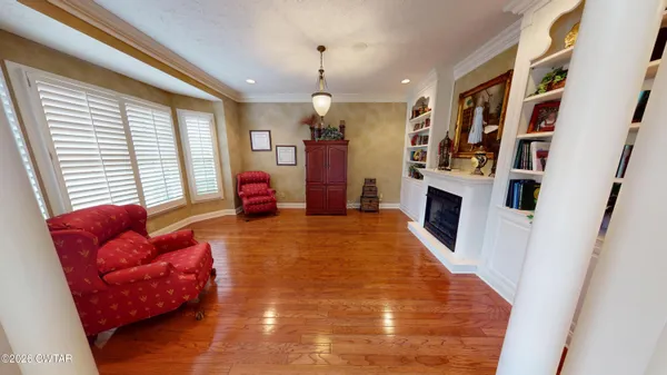 a view of a livingroom with wooden floor and a fireplace