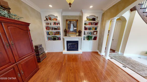 a view of a livingroom with wooden floor and a chandelier