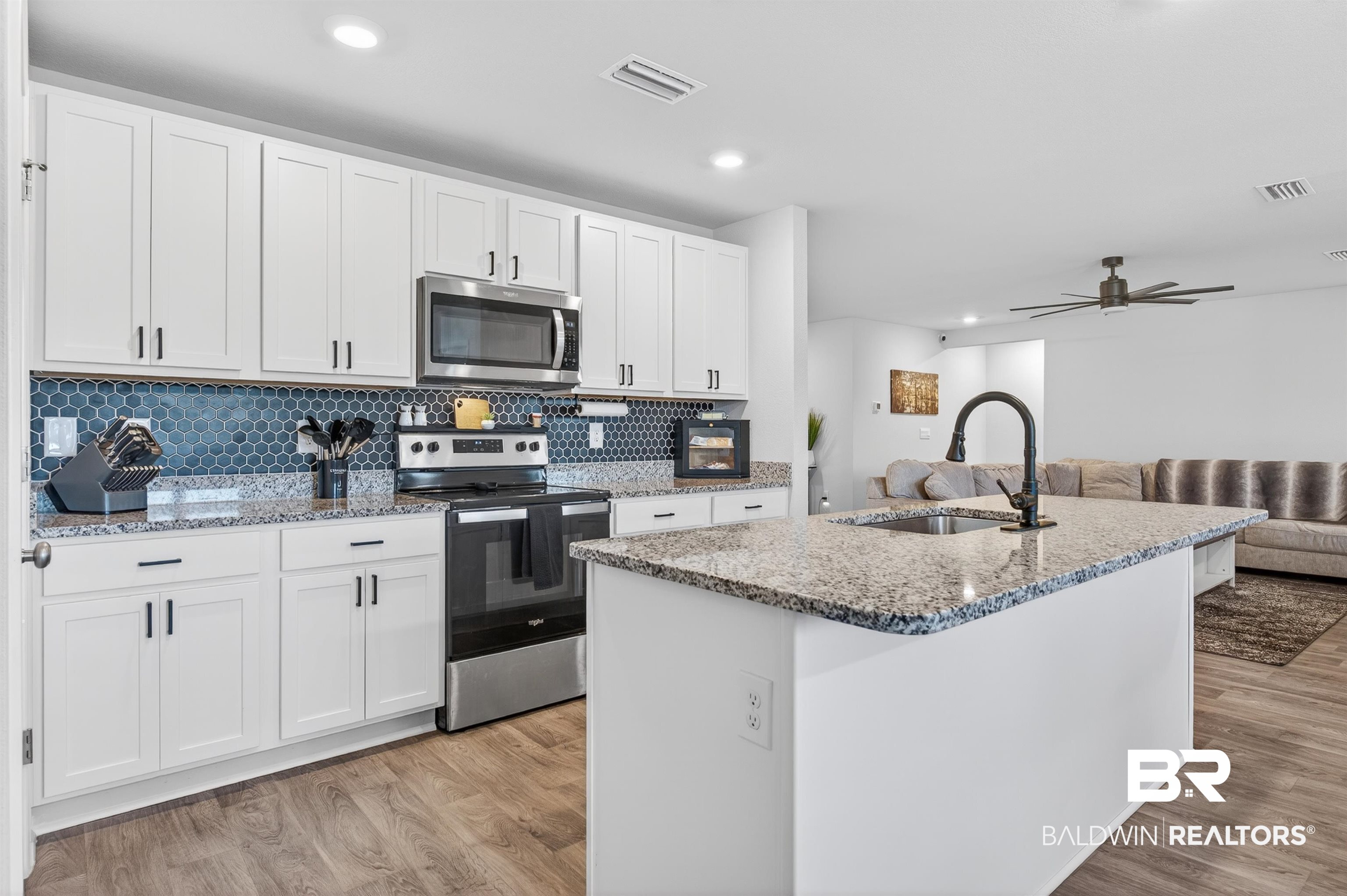 3213 Camino Real Loop Lillian, AL 36549 - Photo 31 of 61 Modern kitchen featuring a central island with an undermount sink and matte black faucet