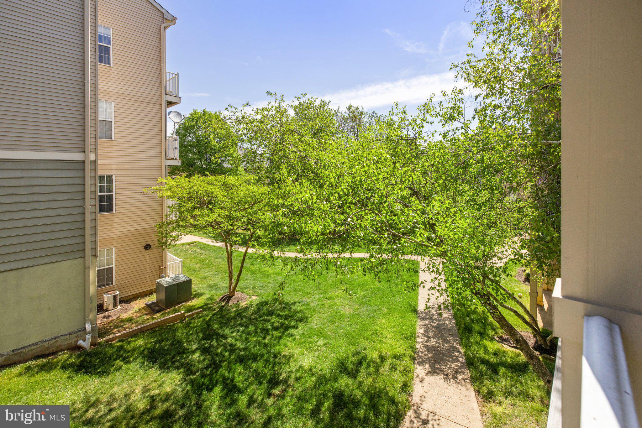 1049 Gardenview Loop, Unit 203 Woodbridge, VA 22191 - Photo 25 of 25 a backyard of a building with large trees and plants
