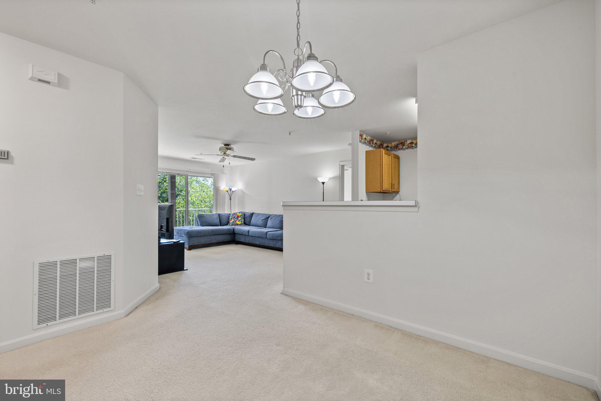 1049 Gardenview Loop, Unit 203 Woodbridge, VA 22191 - Photo 7 of 25 a view of a livingroom and a kitchen with furniture wooden floor and a large window