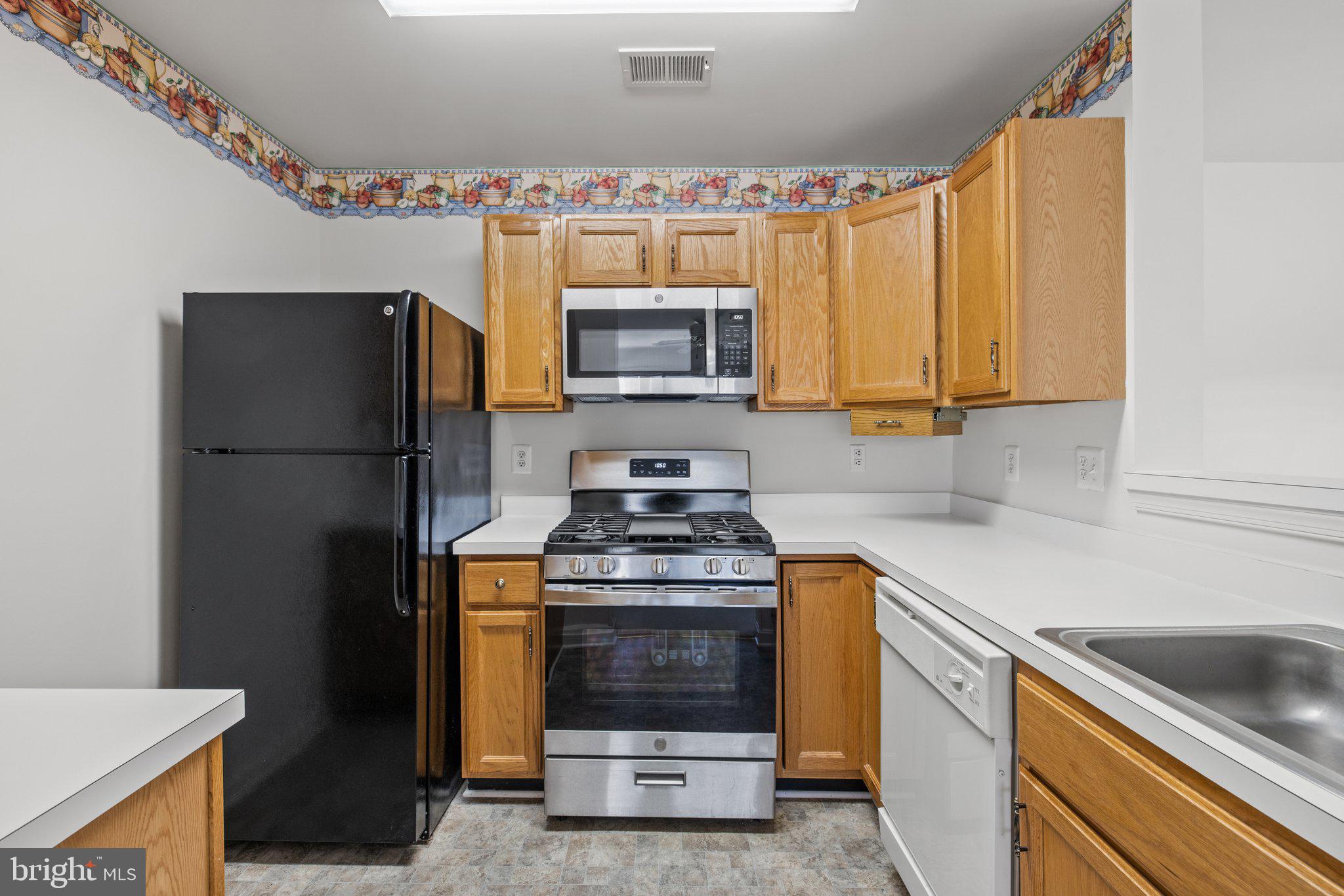 1049 Gardenview Loop, Unit 203 Woodbridge, VA 22191 - Photo 9 of 25 a kitchen with stainless steel appliances granite countertop a stove a refrigerator and a sink