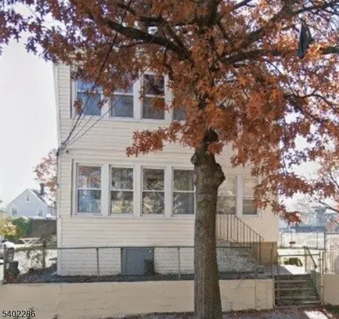 a front view of a house with a tree