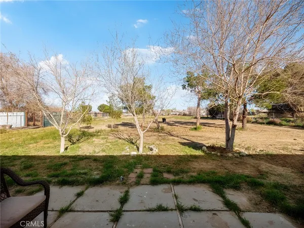 a backyard of a house with barbeque oven table and chairs