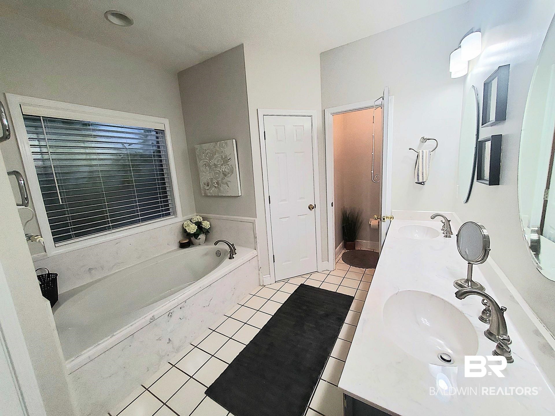 31163 Woodland Way Daphne, AL 36527 - Photo 14 of 44 Bathroom featuring a tub, vanity, and tile patterned floors