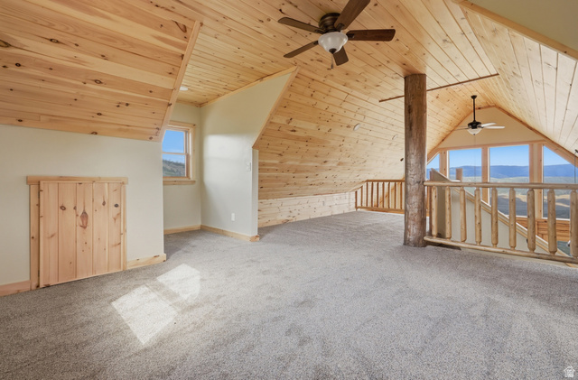 20 Q Puma Road Fairview, UT 84629 - Photo 15 of 27 Spacious loft area featuring natural wood plank ceilings and trim, light-colored carpeting, multiple ceiling fans, and a large window wall offering panoramic outdoor scenery