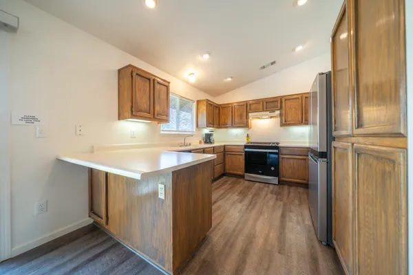 a kitchen with a refrigerator sink and cabinets
