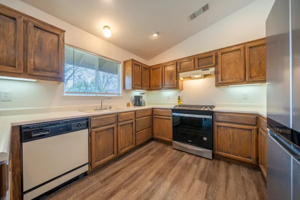 a kitchen with granite countertop wooden cabinets and white appliances
