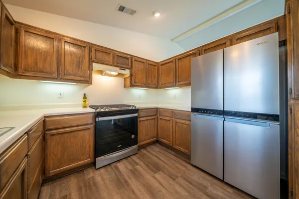 a kitchen with a refrigerator and a stove top oven