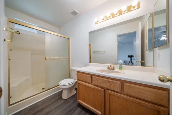 a bathroom with a sink a toilet a mirror and shower