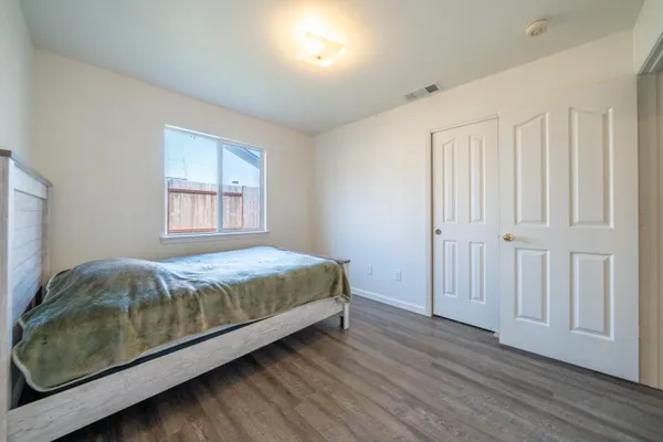 a bed sitting in a spacious bedroom next to a window