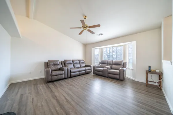 a living room with furniture and wooden floor