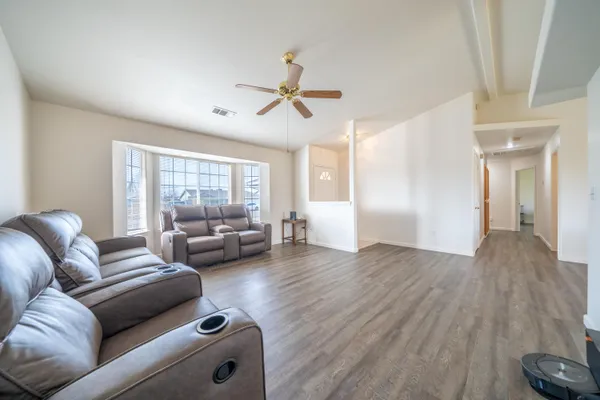 a living room with furniture and a wooden floor