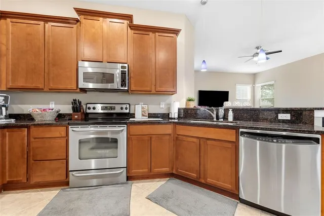 a kitchen with stainless steel appliances granite countertop a stove microwave and sink